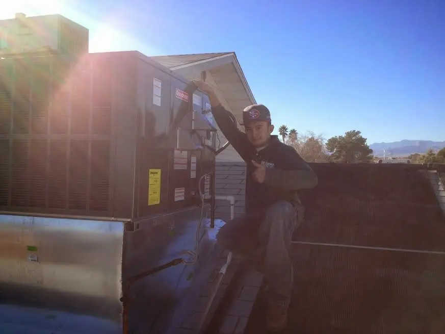HVAC technician performing AC Tune-Up on a rooftop unit in St. Pete Beach